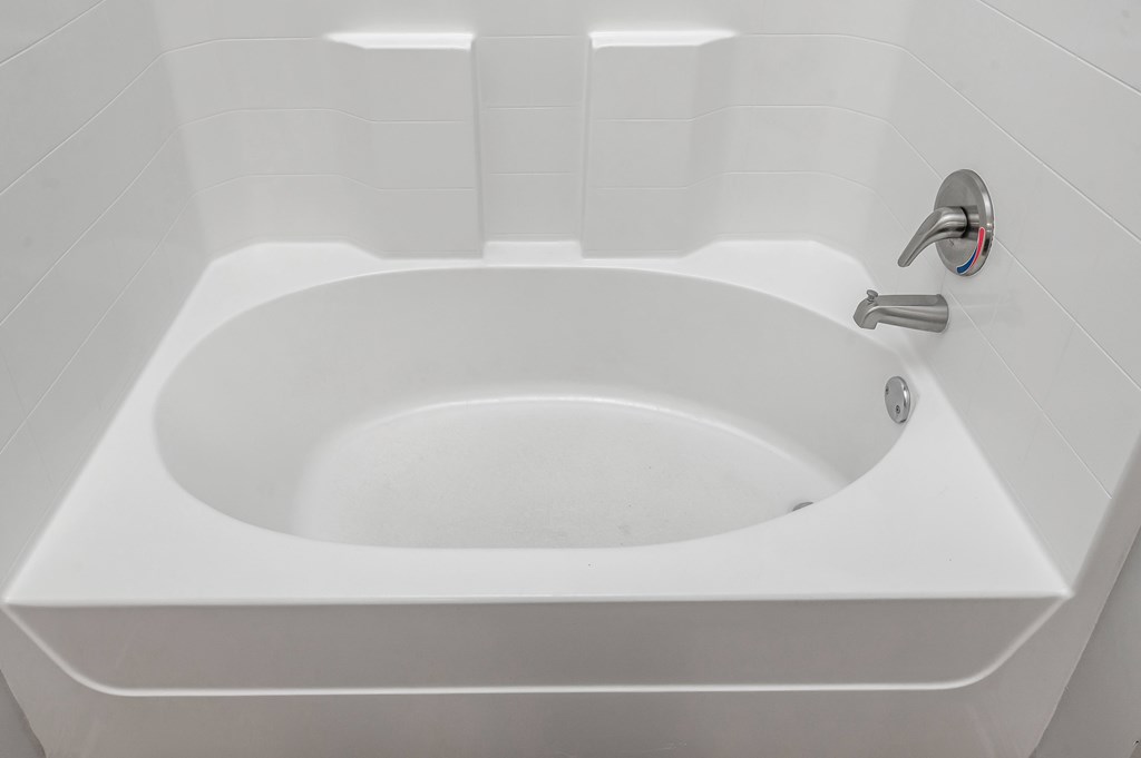 A white sink in a bathroom with a silver faucet.